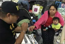  ?? AP PHOTO BY ELLIOT SPAGAT ?? Alain Cisneros, a community organizer for the Immigrant Families and Students in the Struggle, an advocacy group known by its Spanish acronym FIEL, speaks with Adabella Fonseca, a Mexican woman whose parents brought her to the U.S. illegally when she...