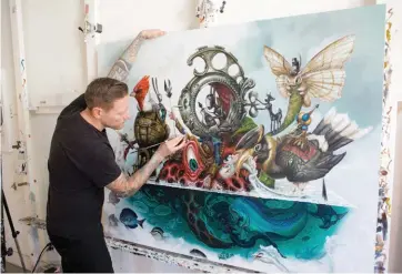  ??  ?? Greg “Craola” Simkins works on The EscapeArti­st, acrylic on canvas.
