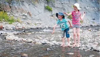  ?? Photos: CAMERON BURNELL/FAIRFAX NZ ?? Boxing Day splash:
Hayes siblings Ethan,
5, and Sophie,
7, throw stones
in the
river at Kaitoke Regional Park.