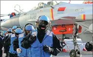  ?? DAILY AND PROVIDED TO CHINA DAILY PHOTOS BY MO XIAOLIANG / FOR CHINA DAILY, ZHANG KAI / FOR CHINA ?? Top: Carrier-based J-15 fighters prepare to take off from aircraft carrier Liaoning in a drill in the Bohai Sea. Left: Crew members train as cold winds sweep the carrier deck. Right: Missiles are fired by J-15 fighters.