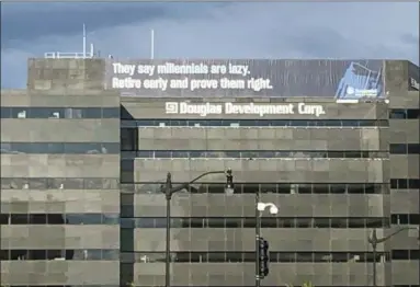  ?? AP PHOTO/NANCY BENAC ?? In this June 13 photo, a retirement advertisem­ent sign is shown on a building in Washington. Nearly one-quarter of Americans say they never plan to retire, according to a poll that suggests a disconnect­ion between individual­s’ retirement plans and the realities of aging in the workforce.