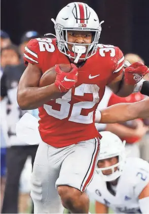  ?? ADAM CAIRNS/COLUMBUS DISPATCH (LEFT); MALCOLM EMMONS/USA TODAY SPORTS (RIGHT) ?? LEFT: Treveyon Henderson ran for 277 yards on Saturday, breaking Archie Griffin’s Ohio State freshman rushing record. On Sept. 30, 1972, freshman Archie Griffin ran for 239 yards against North Carolina to break what was then the Ohio State record for most rushing yards in a single game.