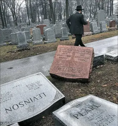  ?? Robert Cohen/St. Louis Post-Dispatch via AP ?? Rabbi Hershey Novack of the Chabad center walks through Chesed Shel Emeth Cemetery in St. Louis on Tuesday, where almost 200 gravestone­s were vandalized over the weekend. “People who are Jewish are shocked and angry,” Rabbi Novack said. President...