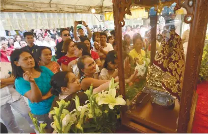  ?? SUNSTAR FOTO / RUEL ROSELLO ?? STO. NIñO. Staff and visitors of Cebu City Medical Center gather around the image of Senior Sto. Niño during its stopover in the facility.