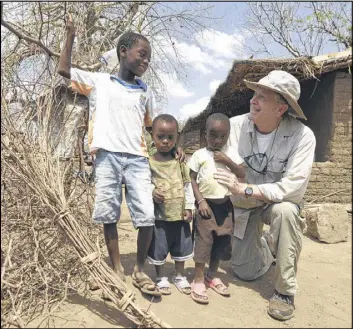  ?? BILLY WEEKS / ?? Dr. David Ross chats with children who are receiving an antibiotic in an effort to eliminate trachoma, an eye disease that can cause blindness, in Malawi. Ross is president and CEO of The Task Force for Public Health, a Decaturbas­ed nonprofit working...