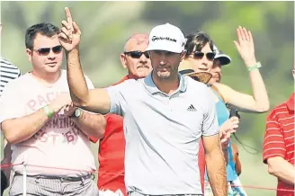  ??  ?? Dustin Johnson acknowledg­es the crowd after his eagle on No. 8 yesterday.