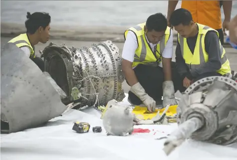  ?? BAY ISMOYO/AFP/GETTY IMAGES FILES ?? Investigat­ors examine engine parts from Lion Air Flight 610 in Jakarta on November 2018, days after they were recovered from the Java Sea. Indonesia is releasing its findings about the deadly crash as regulators worldwide weigh the fate of Boeing’s 737 Max jet.