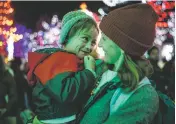  ?? GABRIELA CAMPOS/NEW MEXICAN FILE PHOTO ?? Alejandra Ordoñez and her son, James, enjoy the lights on the Plaza during the annual lighting ceremony in 2022. This year’s event is 4:30 to 8 p.m. Friday.