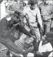  ?? (File Photo/AP/Horst Faas, Michel Laurent) ?? Bangladesh­i guerrillas beat a victim Dec. 18, 1971, as they torture and execute four men suspected of collaborat­ing with Pakistani militiamen accused of murder, rape and looting during months of civil war in Dacca, Bangladesh.