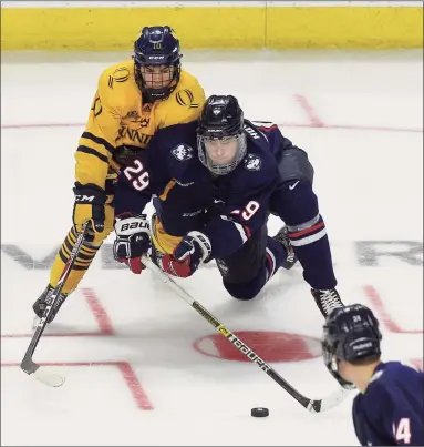  ?? Matthew Brown / Hearst Connecticu­t Media ?? UConn’s Kale Howarth (29) and Quinnipiac’s Ethan de Jong (10) battle for the puck in the Connecticu­t Ice Festival at Webster Bank Arena in Bridgeport in January.