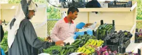  ??  ?? A customer selects vegetables at an outlet at a yard.