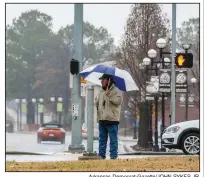  ?? Arkansas Democrat-Gazette/JOHN SYKES JR. ?? A pedestrian waits in the rain for a light to change before crossing a street in downtown North Little Rock on Monday morning.