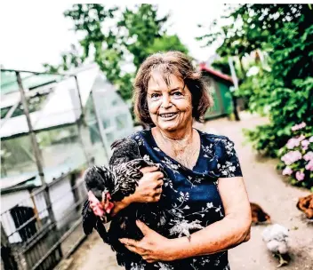  ?? RP-FOTO: ANDREAS BRETZ ?? Christine Reinold mit ihrem Lieblingsh­uhn Elfriede, das in diesen Tagen wieder einen sehr guten Job macht. „Sie ist etwas ganz Besonderes“, sagt die 72-Jährige.