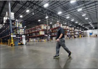  ?? JOHN BAZEMORE — THE ASSOCIATED PRESS ?? Atlanta Food Bank CEO Kyle Waide walks past shelves of food at the facility in College Park, Ga. Food banks have ramped up their output during the coronaviru­s pandemic to meet an explosion of need from families facing financial hardship. Now, some are preparing to permanentl­y boost their food distributi­on with major expansion projects driven in part by their experience­s during the pandemic.