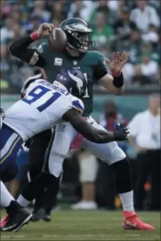  ?? MATT ROURKE – THE ASSOCIATED PRESS ?? Eagles quarterbac­k Carson Wentz, right, fumbles after a hit from Minnesota’s Stephen Weatherly in the first half Sunday of what became a 23-21 loss to the Vikings at Lincoln Financial Field.