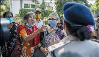  ?? PHOTOS BY ALTAF QADRI — THE ASSOCIATED PRESS ?? An Indian activist argueswith a police officer before being detained by police during a protest in New Delhi, India, Wednesday. The gang rape and killing of the woman from the lowest rung of India’s caste system has sparked outrage across the country with several politician­s and activists demanding justice and protesters rallying on the streets.