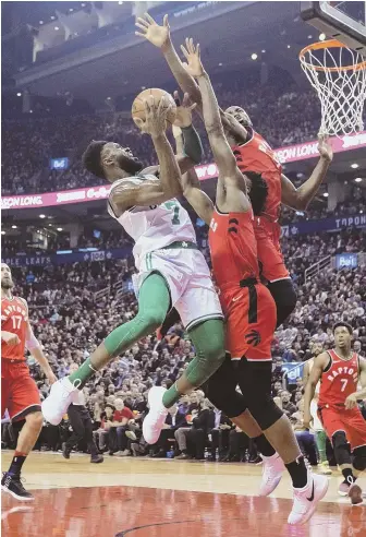  ?? APPHOTO ?? ROAD BLOCK: Jaylen Brown tries to get to the hoop against the Raptors’ OG Anunoby (front) and Serge Ibaka during the Celtics’ 111-91 loss last night in Toronto.