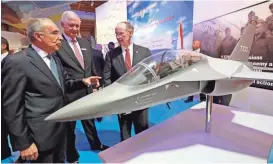  ??  ?? Leonardo President Filippo Bagnato, Leonardo DRS CEO Bill Lynn and Ala Gov. Robert Bentley talk near a model of the proposed T-100 jet trainer at the Leonardo DRS T-100 trainer jet announceme­nt on Thursday in Tuskegee, Ala.