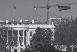  ?? Bill O'Leary/The Washington Post ?? Greenpeace activists commandeer a constructi­on crane and unfurl a huge banner reading "RESIST" a few blocks from the White House this week.