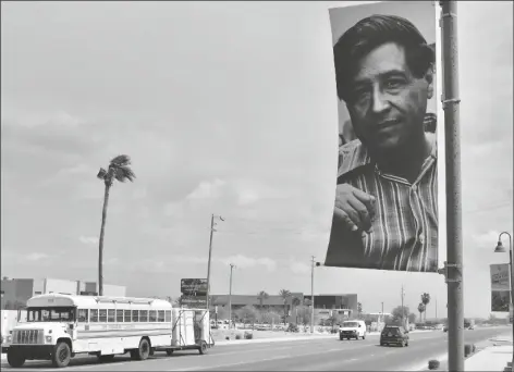  ?? PHOTO BY CESAR NEYOY/BAJO EL SOL ?? A FARM LABOR BUS STOPS ON MAIN STREET IN SOMERTON, where banners hang in honor of late UFW leader Cesar Chavez, whose birthday is Wednesday.