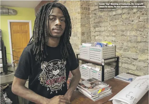  ?? BRIAN RICH/SUN-TIMES ?? Isaiah “Zay” Manning at Contextos, the nonprofit where he works. He was wounded in a 2018 shooting.