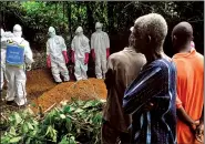  ?? AP/ABBAS DULLEH ?? standing by, a funeral is held Saturday in Monrovia, Liberia, for a woman suspected of having died of Ebola.