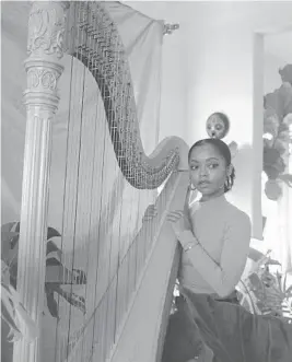  ?? RIKKI D WRIGHT/THE NEW YORK TIMES ?? Madison Calley, seen at home Feb. 25, posts her harp performanc­e videos to social media.