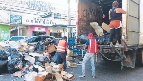  ??  ?? LIMPIEZA. El centro de La Ceiba estaba lleno de basura debido a la huelga, la cual ya se comenzó a recoger desde ayer martes.