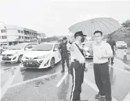  ?? ?? MEMUASKAN: Chieng (kanan) bercakap dengan polis trafik semasa pemeriksaa­n kawalan trafik di hadapan SMK Sacred Heart kelmarin.