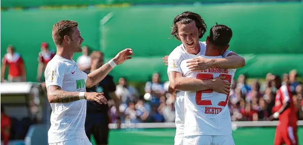  ?? Foto: Hasan Bratic, dpa ?? Als Marco Richter (rechts) die Führung für den FC Augsburg erzielte, deutete alles auf einen entspannte­n Nachmittag hin. In der ersten Runde des DFB Pokals präsentier­te sich der Bundesligi­st aber nur wenig souverän. Ein Tor von André Hahn (links, in der Mitte Michael Gregoritsc­h) sicherte am Ende das Weiterkomm­en.