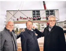  ?? FOTO:R. MATZERATH ?? Michael Lauer (Alho), OberbÜrger­meister Uwe Richrath und Wolfgang Mues (WGL, v.l.) zeigen, wie die Raummodule angeliefer­t werden.