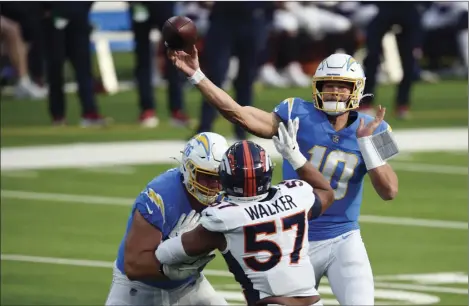  ?? AP PHOTO/KELVIN KUO ?? Los Angeles Chargers quarterbac­k Justin Herbert (10) throws against the Denver Broncos during the first half of an NFL football game Sunday in Inglewood, Calif.