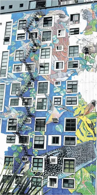  ?? PHOTOGRAPH BY ANALY LABOR FOR THE DAILY TRIBUNE @tribunephl_ana ?? Art transforma­tion A vast mural adorns the wall of the Sterten Place building along Maginhawa Street, Teacher's Village, Quezon City. The empty wall canvass was transforme­d by environmen­tal activist and multi-media painter AG Saño and fellow artists that features different large-scale colorful birds and dolphins.