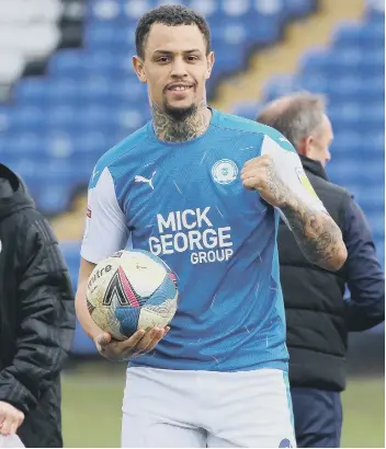  ??  ?? Jonson Clarke-Harris with the matchball after his hat-trick against Accrington. Photo: Joe Dent/theposh.com