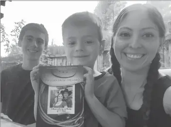  ?? Courtesy photo ?? Erika Seibert and her sons, Noah, left, and Nathan show off Seibert’s book, “On Loan from the Lord,” a memoir of the life and ministry of Seibert’s late husband. J.D. Seibert, a pastor, died May 4, 2016, at age 37 of acute myeloid leukemia. Erika Seibert said she wrote the memoir as a way to honor him.