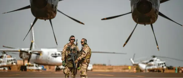  ?? Foto: Arne Immanuel Bänsch, dpa ?? Deutsche Soldaten stehen am Flughafen in Gao und sichern ein Transportf­lugzeug. Nach dem Afghanista­n‰Desaster rückt der Einsatz in Mali in den Blickpunkt.