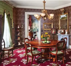  ??  ?? BELOW The dining table and chairs, as well as the buffet table, are ca. 1820s-30s. The Scalamandr­é wallpaper was recolored to complement the carpet. The mirror with a reverse-painted scene is pre-Civil War.