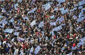  ?? — AFP ?? People hold Greek flags as they demonstrat­e to urge the government not to compromise in the festering name row with neighbouri­ng Macedonia, at the Syntagma Square in Athens, on Sunday.