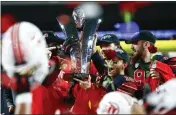  ?? CHASE STEVENS — THE ASSOCIATED PRESS FILE ?? Utah players celebrate with the trophy after their victory over Oregon to win the Pac-12 Conference championsh­ip in December. The Pac-12 announced it was scrapping its divisional format for the coming season on Wednesday.