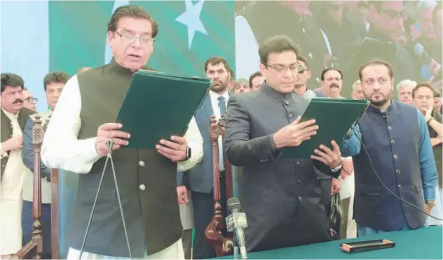  ?? Agence France-presse ?? ↑
Raja Pervez Ashraf (left) administer­s the oath to Hamza Shahbaz Sharif (centre) as the chief minister of Punjab province in Lahore on Saturday.