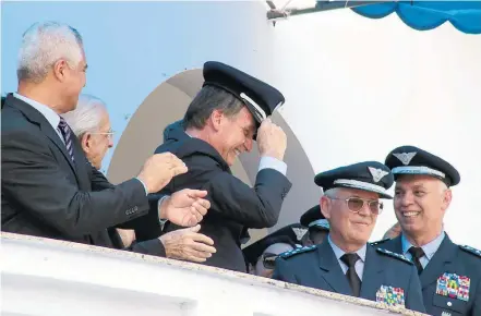  ?? PEDRO IVO PRATES ?? São Paulo. Jair Bolsonaro põe quepe na cabeça ao participar da formatura de sargentos da Aeronáutic­a em Guaratingu­etá