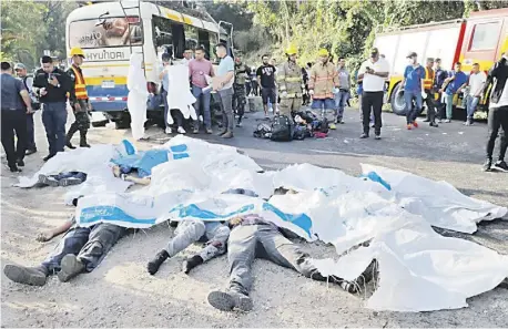  ?? STRINGER/AGENCE FRANCE-PRESSE ?? RESCUE teams cover the victims of a crash between two buses that left several dead, at a highway that connects the municipali­ties of Santa Rosa de Copan and Gracias, in Honduras. At least 15 people died this Wednesday and an unknown number were injured when two buses collided on a highway in northwest Honduras, firefighte­rs reported.