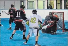  ?? ANNA TAYLOR, SPECIAL TO THE EXAMINER ?? Peterborou­gh Timbermen's Joe Wasson (11) watches as Timbermen goaltender Brett Perras makes a save Saturday.