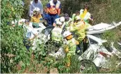  ?? — AP ?? Emergency officers work to rescue Samuel from wreck of his car in New South Wales on Monday.