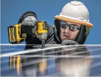  ?? ?? Richard Vallejos with Positive Energy Solar installs solar panels at Casa Milagro on Wednesday.