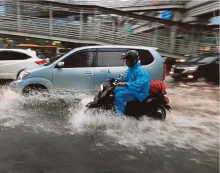  ?? PIC
REUTERS ?? A man riding his motorcycle through a flooded street in Jakarta recently. A coastal city built on a swampy plain, Jakarta faces no end to flood worries because 40 per cent of it is below sea level.