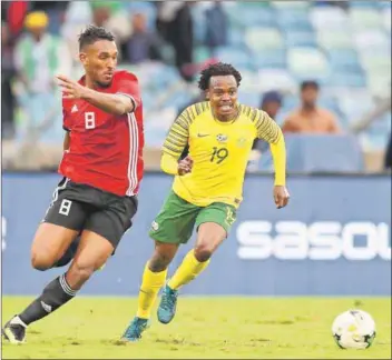  ??  ?? Photo: Buda Mendes/Getty Images) On form: Percy Tau of South Africa and Sand Masaud M Masaud of Libya race for the ball in a 2019 Africa Cup of Nations qualifying match. Coach Stuart Baxter is relying on the onform Tau and Dino Ndlovu to score for South Africa. Photo: Anesh Debiky/Gallo Images