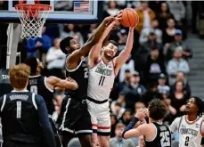  ?? Jessica Hill/associated Press ?? Uconn forward Alex Karaban pulls down a rebound against Georgetown forward Supreme Cook in the first half on Sunday in Hartford, Conn.