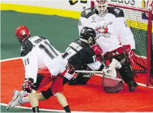  ?? PHOTOS: MIKE DREW ?? Calgary Roughnecks defender Greg Harnett puts a wrap on Edmonton’s Robert Church during NLL action.