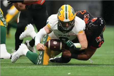  ?? The Canadian Press ?? Edmonton Elks quarterbac­k Nick Arbuckle falls under B.C. Lions defensive lineman Sione Teuhema during second half CFL action in Vancouver on June 11.